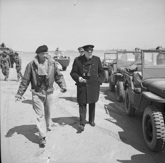 General Sir Bernard Montgomery, commanding 21st Army Group, guides Winston Churchill to his jeep after the Prime Minister had come ashore to begin his tour, 12 June 1944. Kuvan lähde on ww2today.com